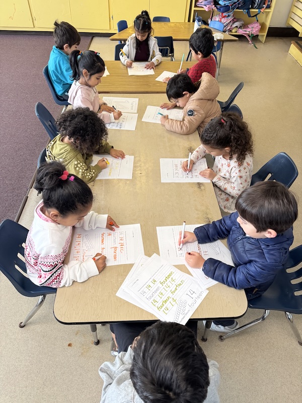 Children writing at tables at Adventure Montessori Academy